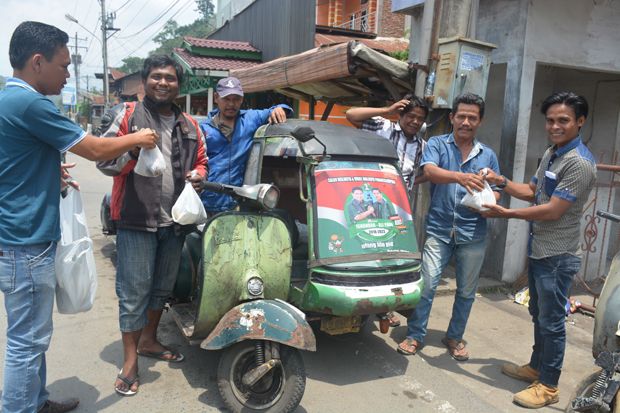 Tim Relawan Isnandar Bagikan Nasi Bungkus kepada Penarik Betor