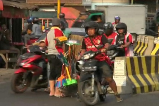 Polisi Nyamar Jadi Pedagang Sapu, Ingatkan Pemotor Tidak Melawan Arus