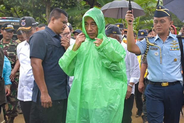 Kunjungi Lokasi Banjir, Jokowi Kenakan Jas Hujan Pemberian Warga