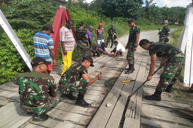 Bersama Warga Papua, Prajurit Yonif Raider 509 Perbaiki Jembatan