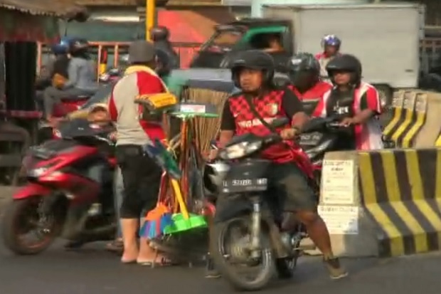 Polisi Nyamar Jadi Pedagang Sapu, Ingatkan Pemotor Tidak Melawan Arus