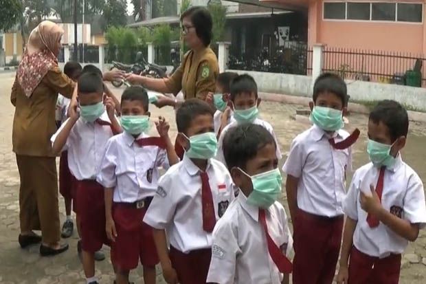 Kabut Asap di Medan Semakin Menebal, Guru SD Bagikan Masker untuk Siswa