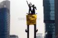 Aktivis Greenpeace Bentangkan Spanduk di Patung Selamat Datang