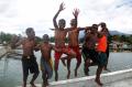 Cerianya Anak-Anak Papua Bermain di Dermaga Pantai Yahim